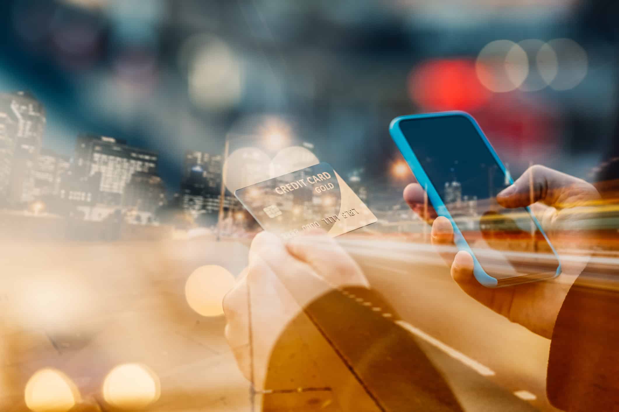 Man using credit card and smartphone for online shopping.