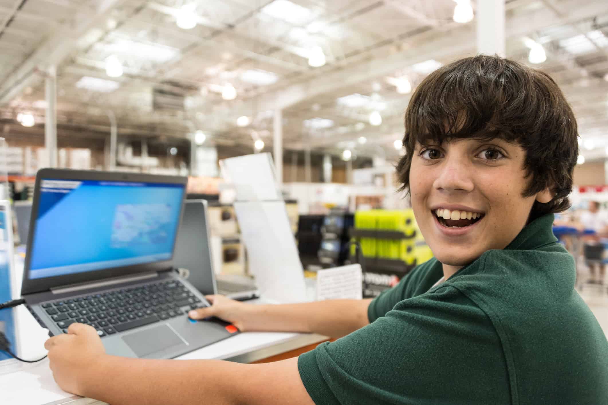 Smiling boy holding new laptop