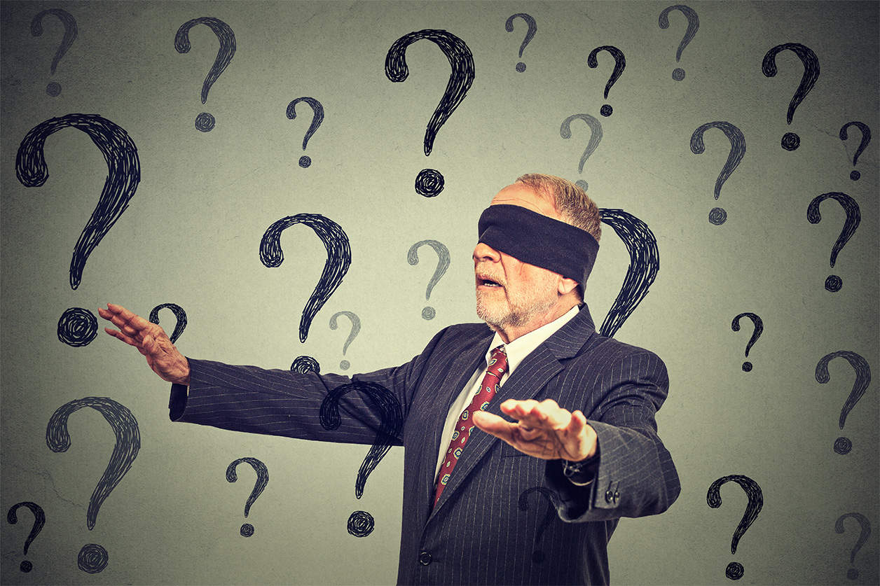 Man in suit blindfolded with questions