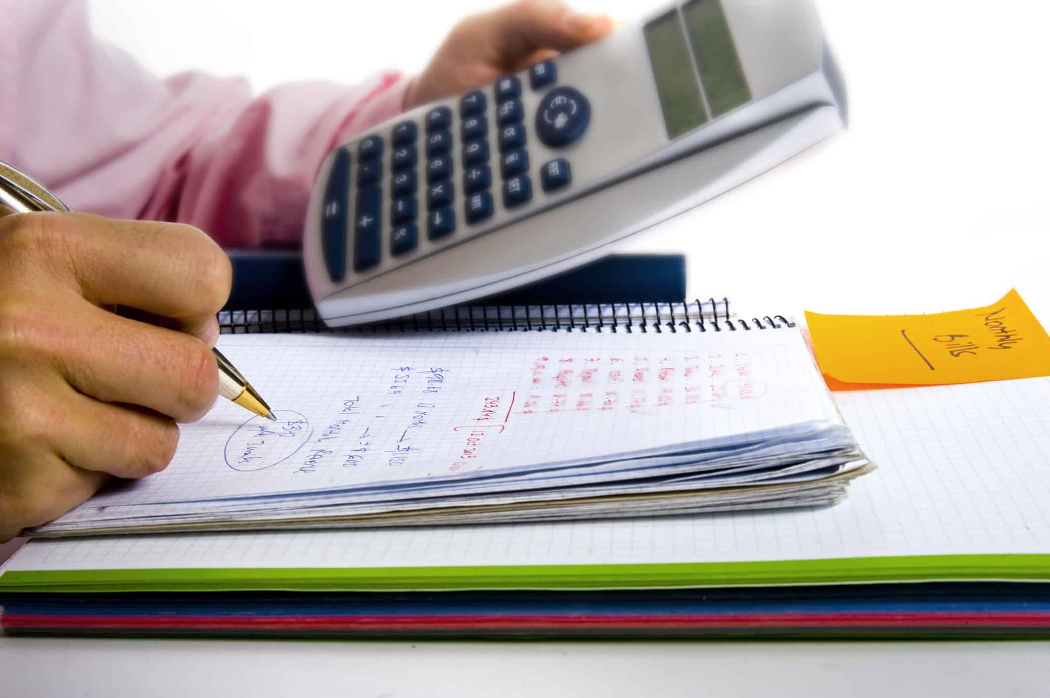 A man's hand holding a calculator putting together a budget