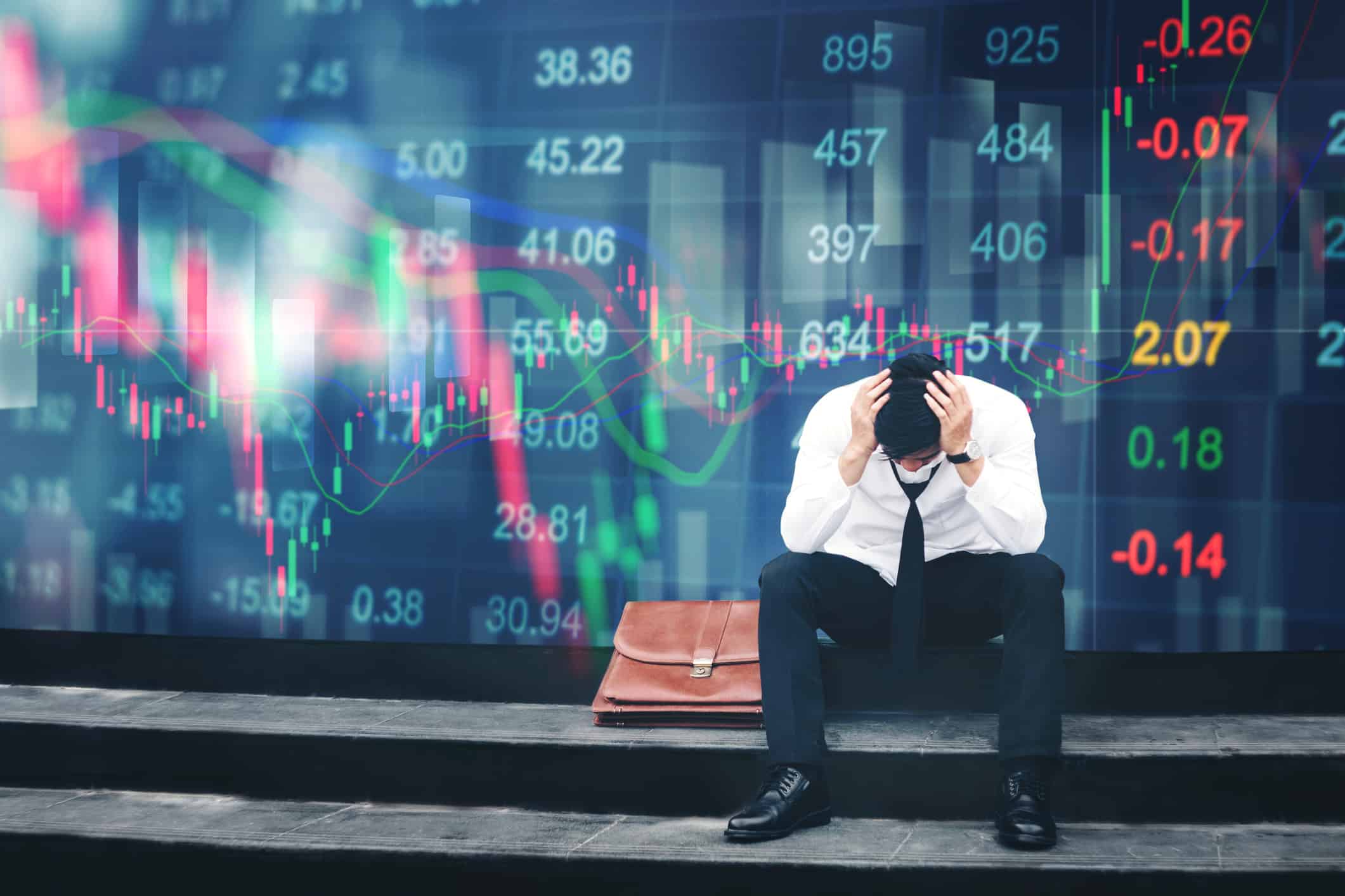 Stressed businessman sitting on the walkway in panic digital stock market financial background.