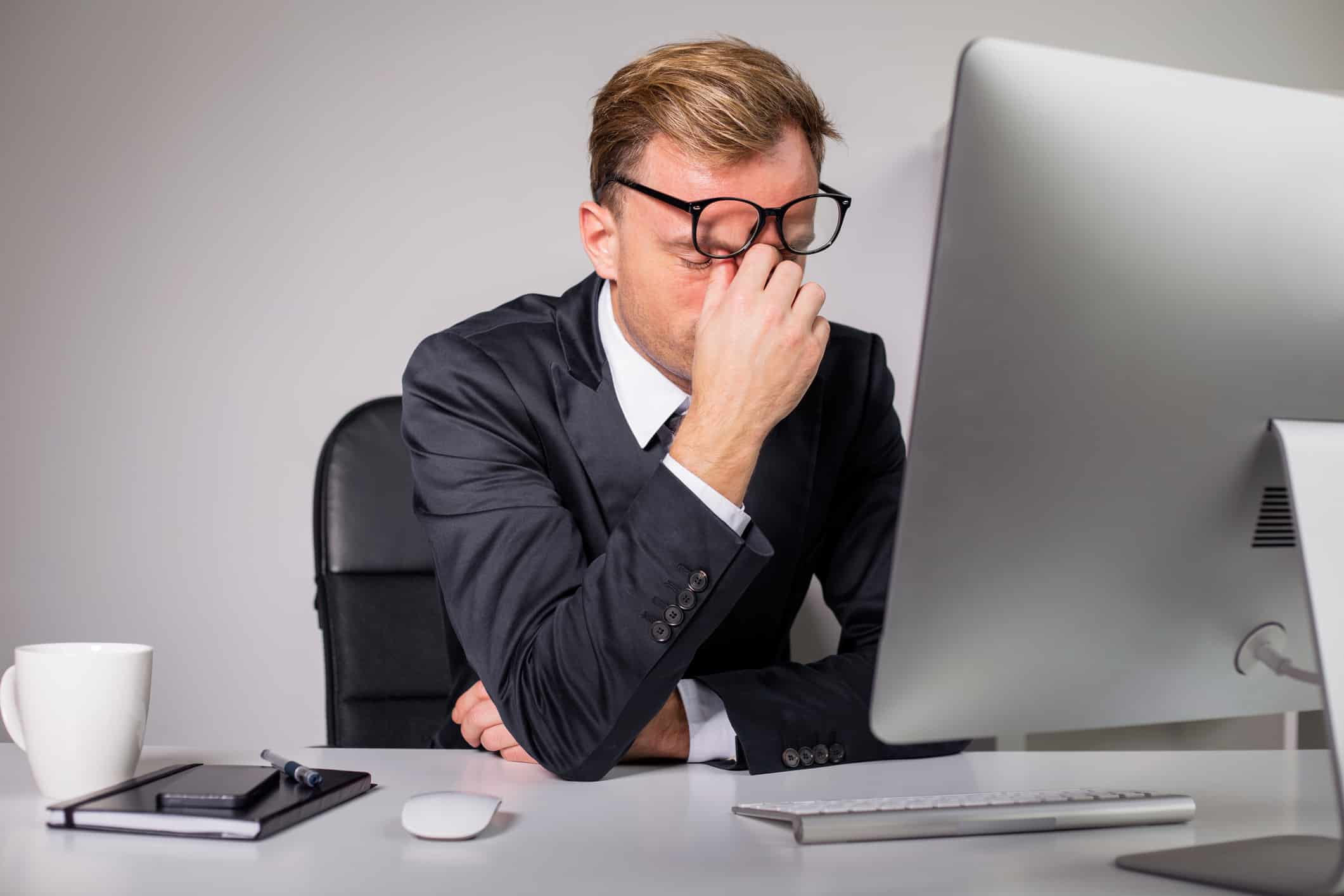 Man after long day holding his glasses