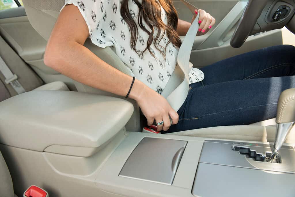 lady putting her seat belt on in car