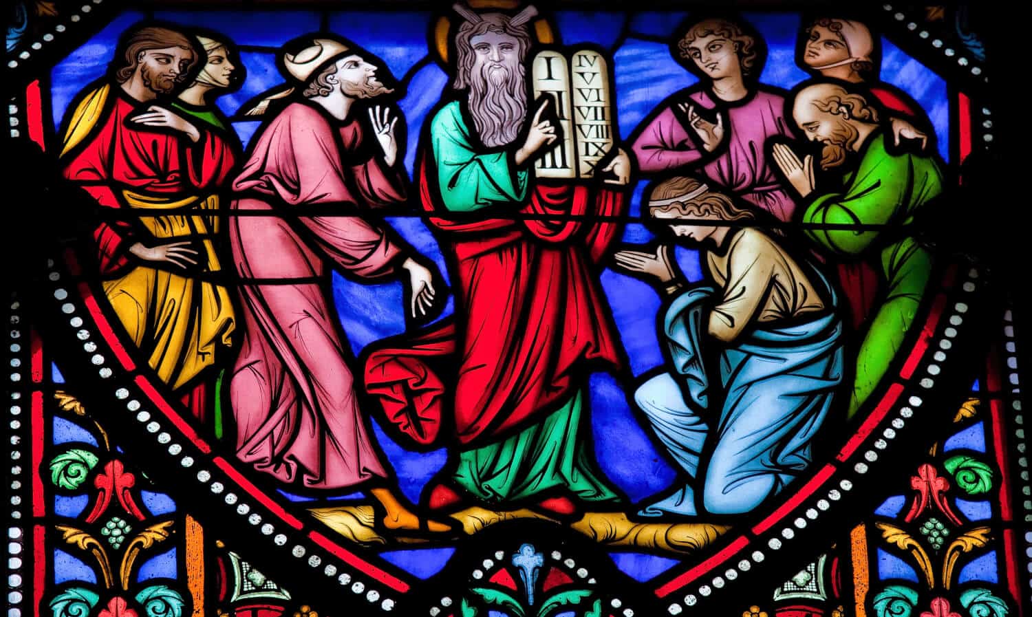 Stained glass window of Moses carrying the 10 Commandments. Which Commandment can predict your debt?