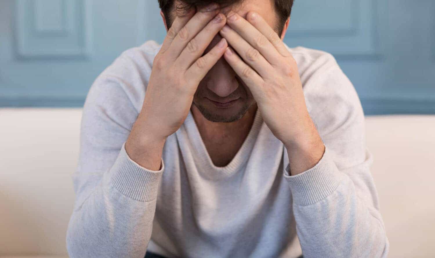 Millennial man hides his face because he has is afraid of credit cards