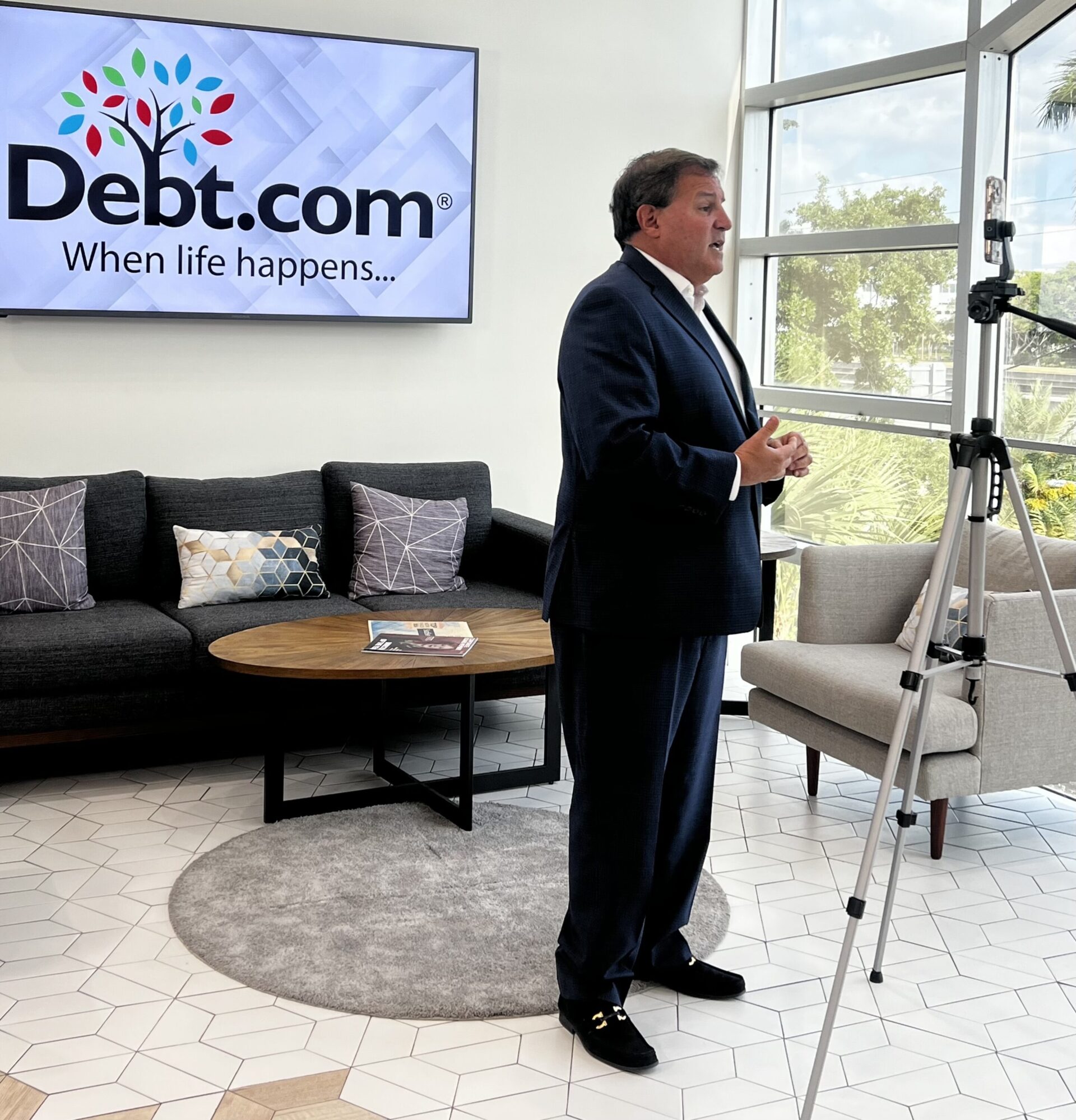 Howard Dvorkin standing in the lobby of the Debt.com building giving an interview